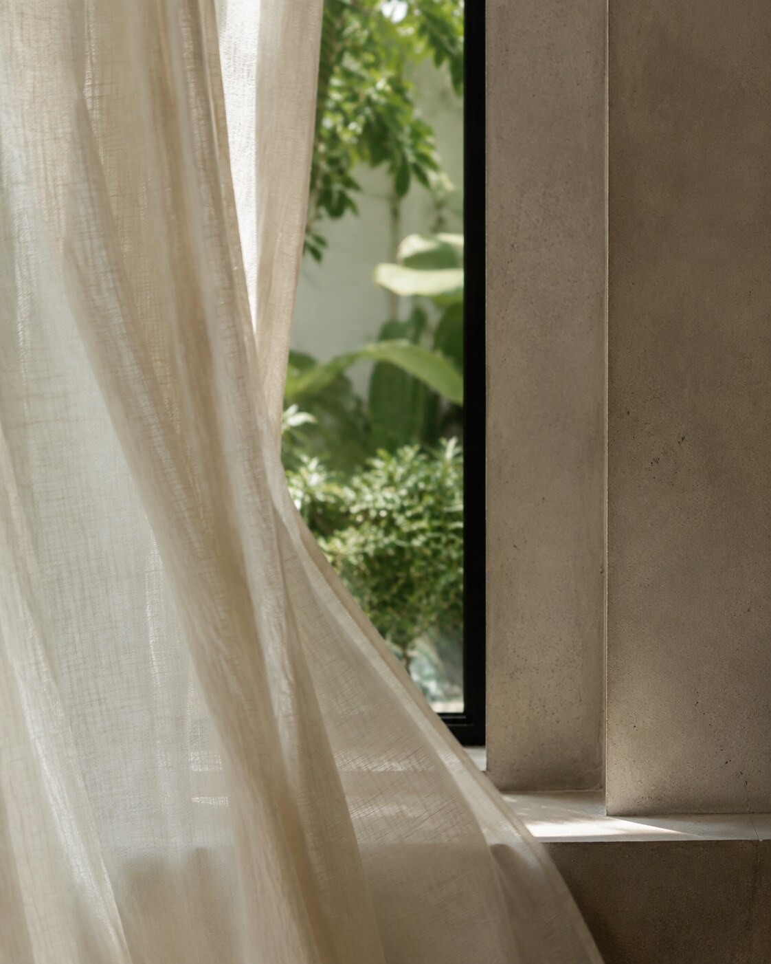 Linen curtain beside concrete window